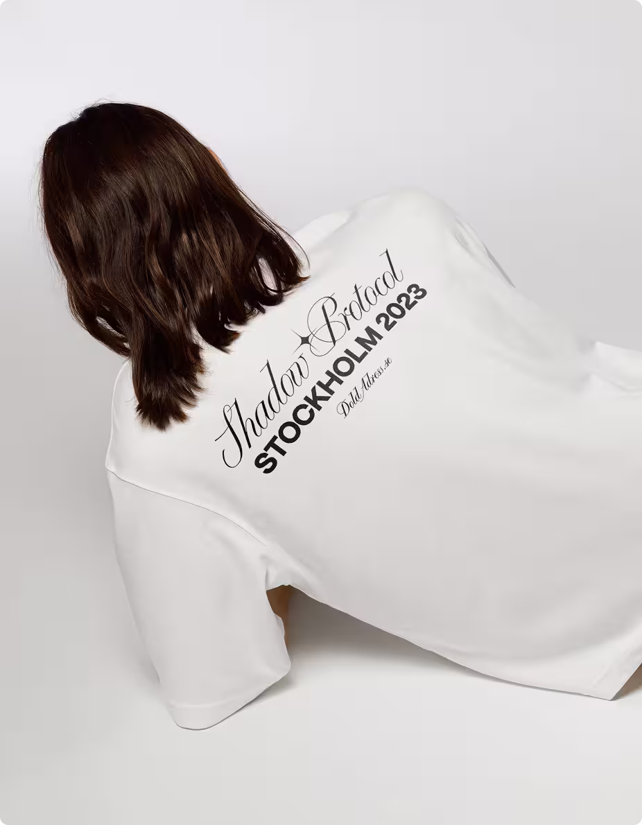 Person med ryggen mot kameran bär en vit t-shirt med svart texten 'Shadow Protocol STOCKHOLM 2023' och logotypen DoldAdress.se.